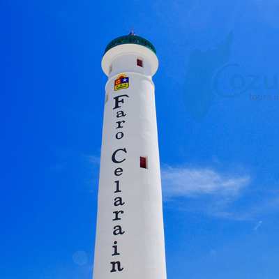 Tall white lighthouse with 'Faro Celarain' text against a clear blue sky.